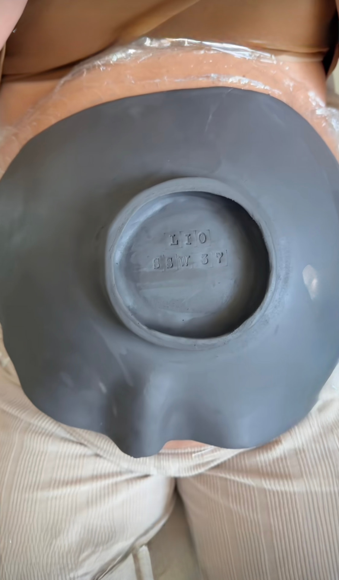Clay belly mold being formed over a pregnant belly